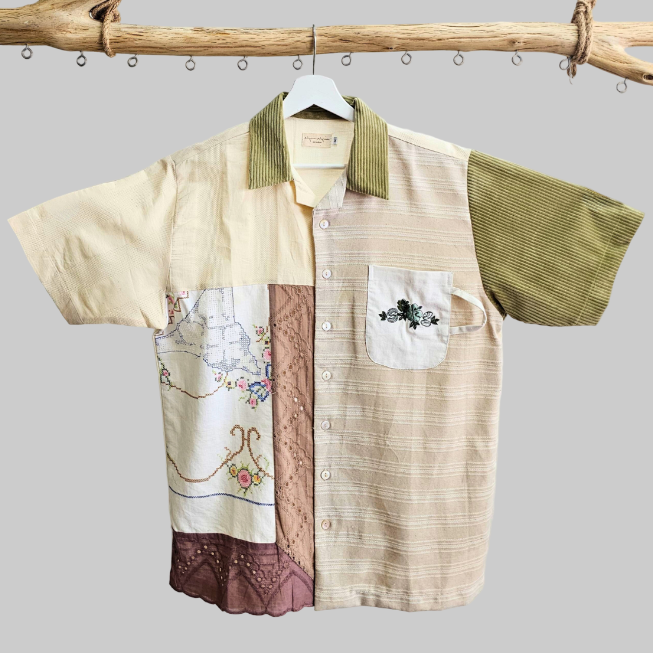 Close-up of artisanal embroidery featuring traditional Kopi and Karipap motifs on a premium sustainable cotton shirt.