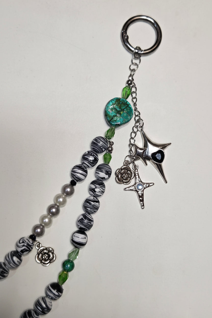 Keychain with beads and charms on a light gray background
